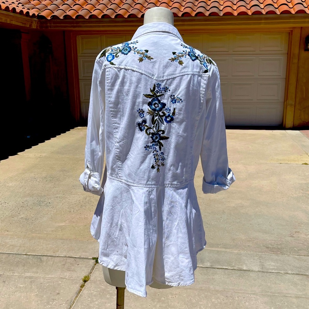 Embroidered blouse with delicate floral design.